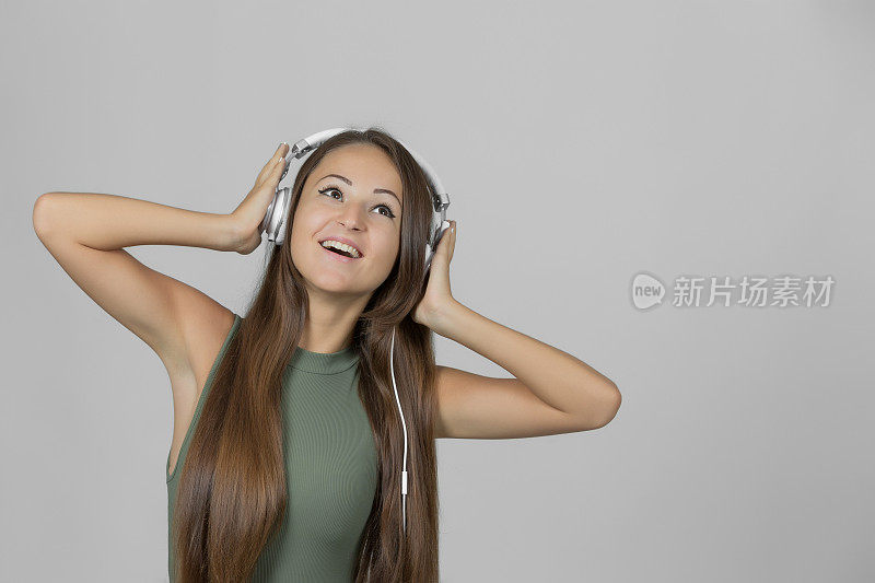 快乐的女人戴着耳机听音乐