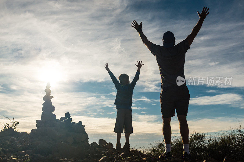 爸爸和儿子在山顶上庆祝