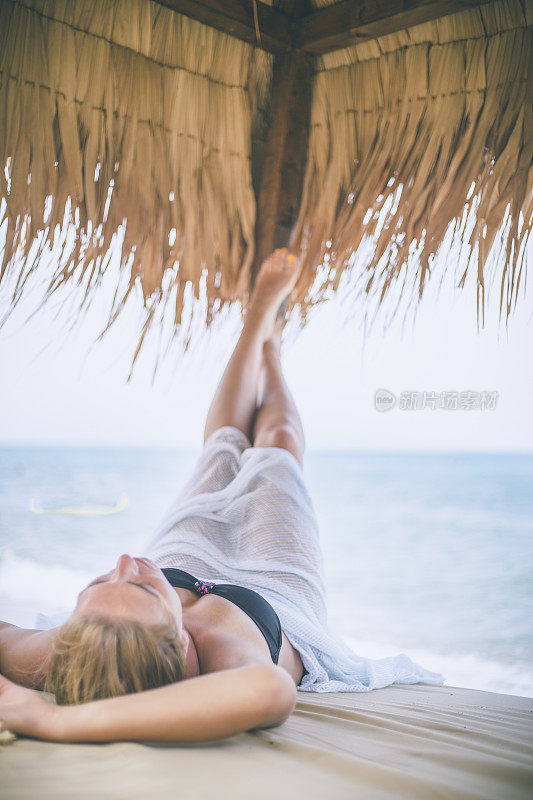 年轻的女子在夏天望着天空和大海