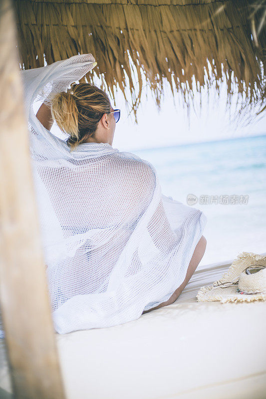 年轻的女子在夏天望着天空和大海