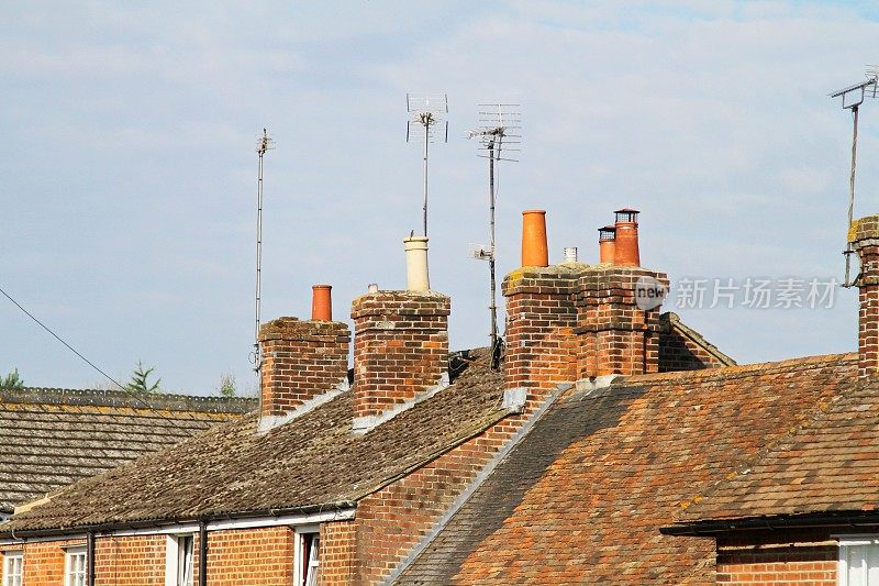 维多利亚时代的陶土烟囱和瓦片屋顶上的砖烟囱