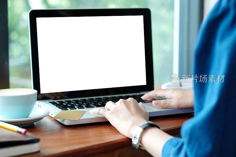 女人手敲笔记本电脑的空白屏幕模拟，而坐在咖啡馆，技术和生活方式的概念