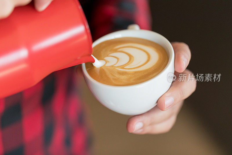 咖啡师用牛奶泡沫装饰
