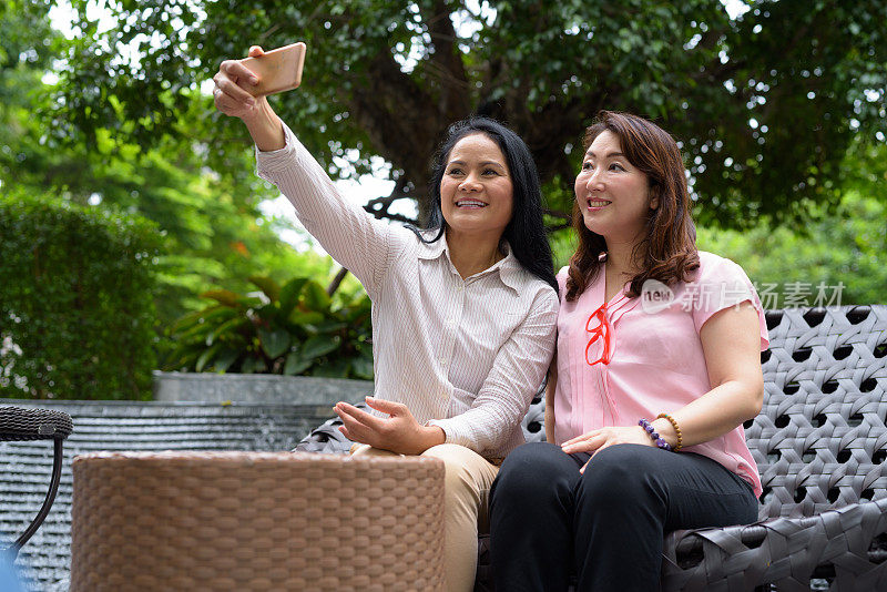 两个成熟的亚洲女性朋友享受生活在暹罗广场在泰国曼谷