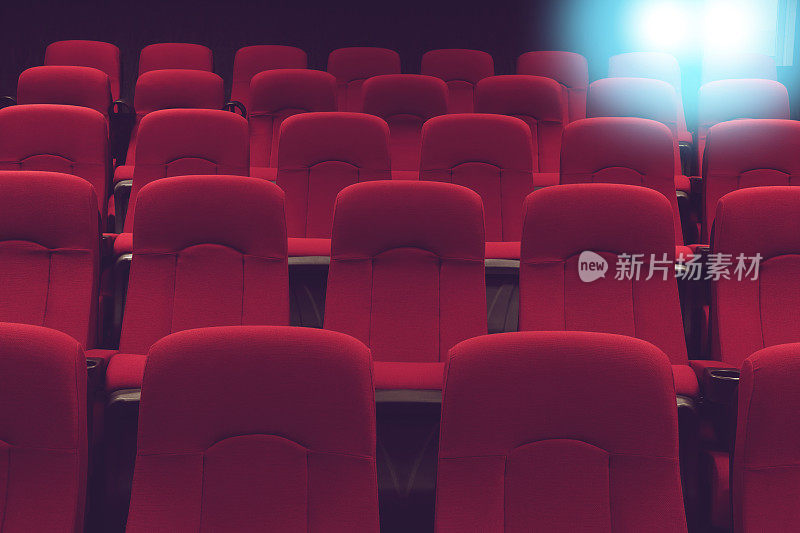 电影院空荡荡的礼堂，红色的座位和蓝色的灯光