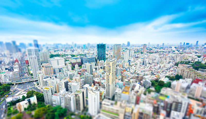 城市天际线鸟瞰图从东京塔在戏剧性的阳光和早晨蓝色多云的天空在东京，日本。微型Tilt-shift效应