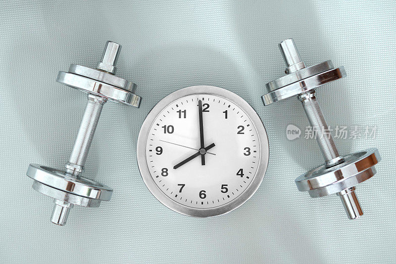 训练:一个圆形时钟旁边放着银色哑铃，表示八点