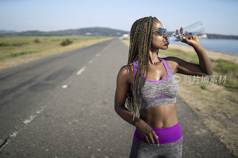 非洲女运动员在路上休息和饮水