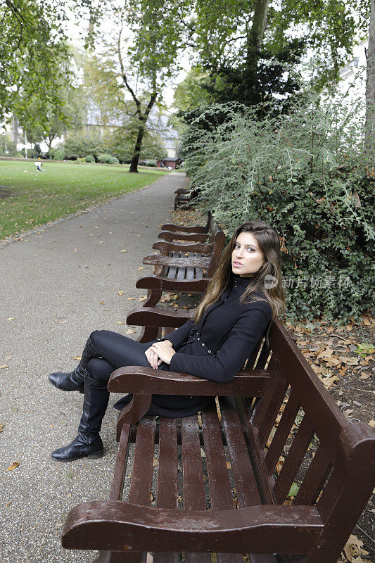城市时尚伦敦俄罗斯户外女孩黑色服装手在膝上