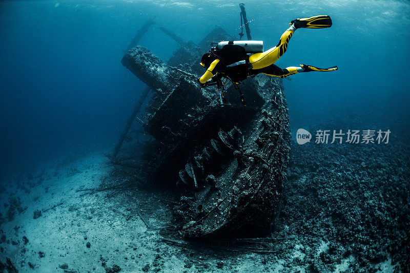 戴水肺的潜水员在红海中环绕着一艘生锈的旧水下沉船