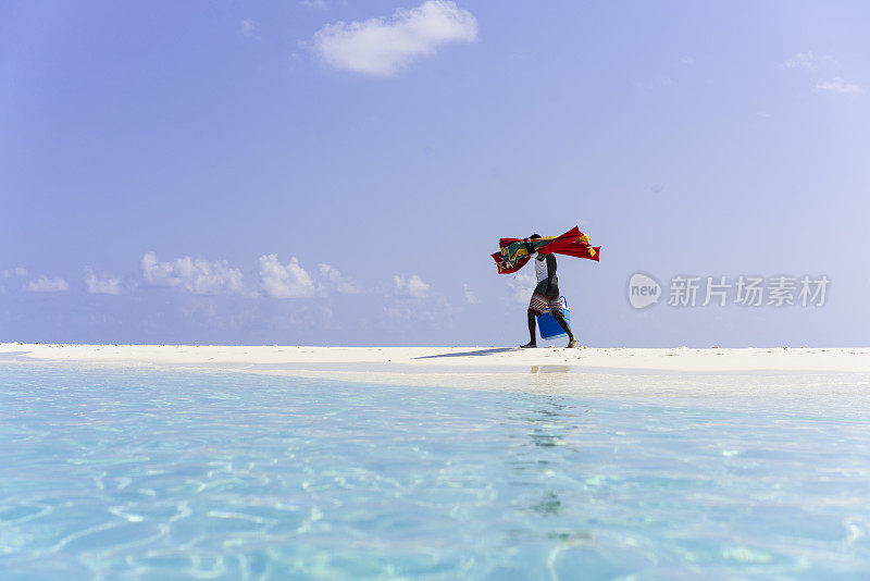 4月，在马尔代夫的沙洲岛海滩上，一名当地人正在照看太阳伞和午餐篮