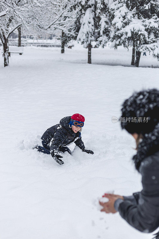 妈妈和她的儿子在打雪仗