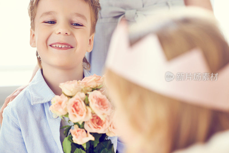 微笑的男孩赠送鲜花作为礼物