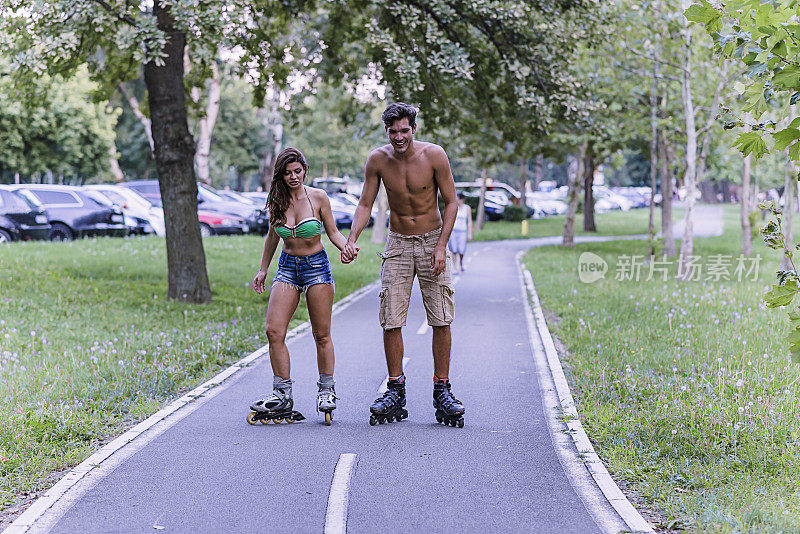 一对年轻夫妇在公园里滑旱冰鞋