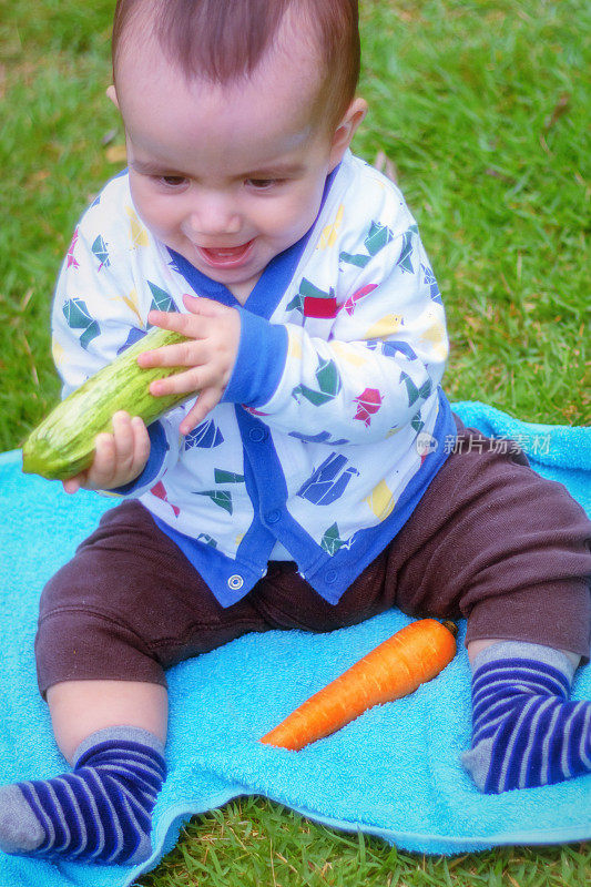 漂亮的宝宝在水果和蔬菜上玩耍。