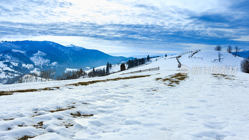 山峰上的雪被风吹走了。冬天的风景。天很冷，下着雪。