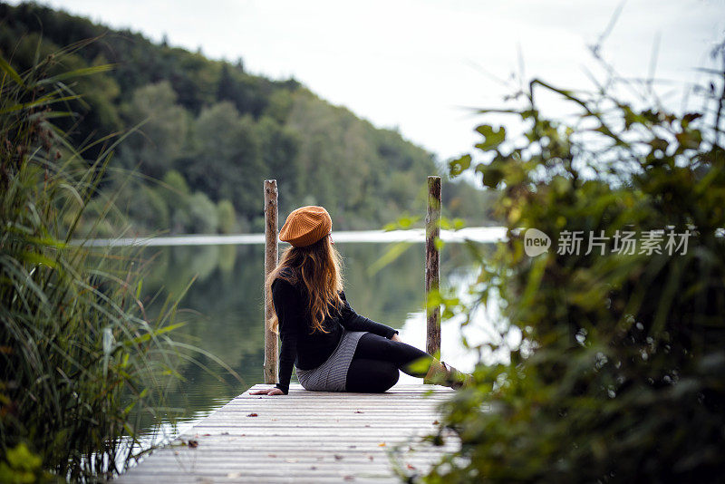 一个女人在奥地利一个美丽的湖边的码头上