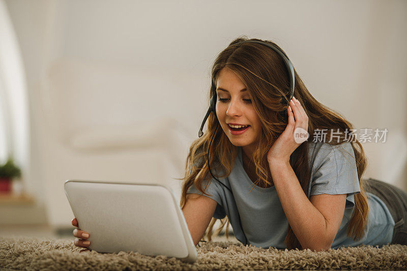 一名年轻女子用耳机在她的数码平板电脑上进行视频通话