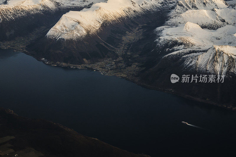 乘客从飞机上俯瞰挪威的峡湾，山上覆盖着积雪