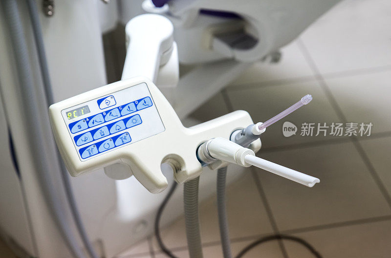 牙科医生手中的唾液喷射器。牙科诊所的牙科设备。牙科医生的一天
