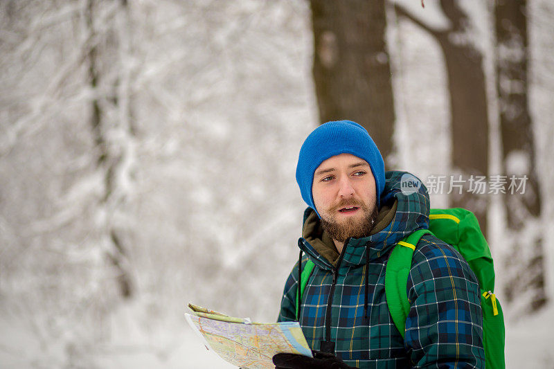 年轻英俊的男子在滑雪运动服山和看别处