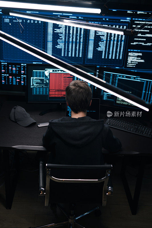 一个电脑黑客在笔记本电脑上的显示器背景上编写代码的俯视图。