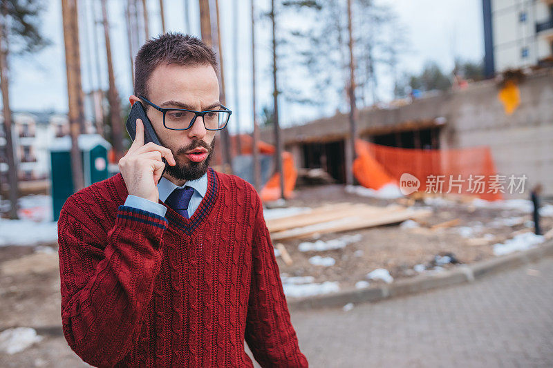 年轻建筑师站在工地前