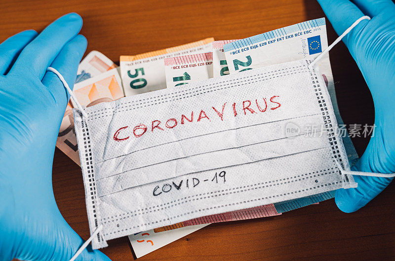 手拿欧元钞票，用冠状病毒这个词盖住口罩