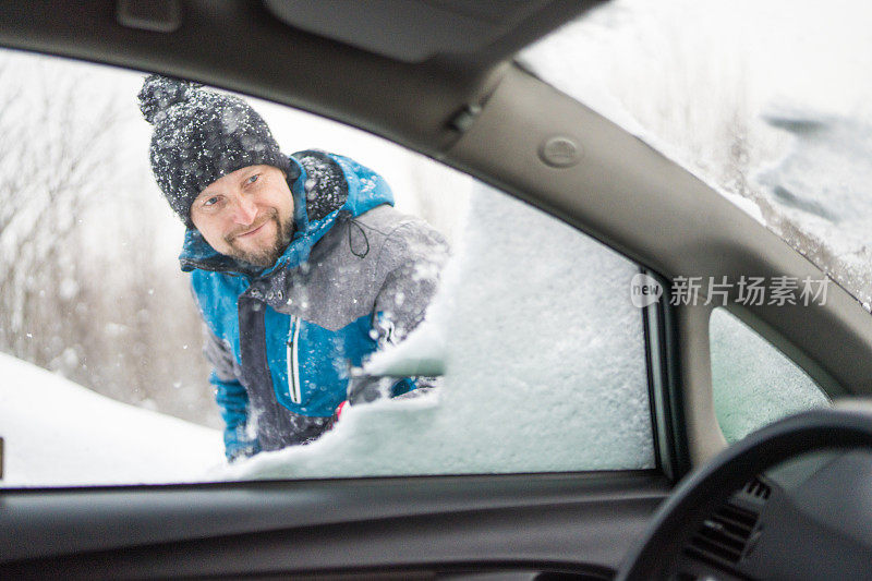 刮着车窗外的冰雪，男人正看着车窗外