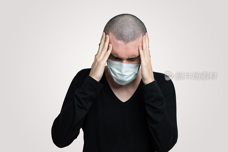 一名年轻人感染了冠状病毒，他头痛，他戴着口罩