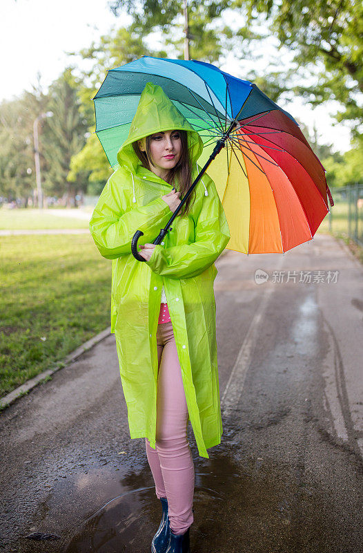 漂亮凉爽的女人带着五颜六色的雨伞在秋天的一天