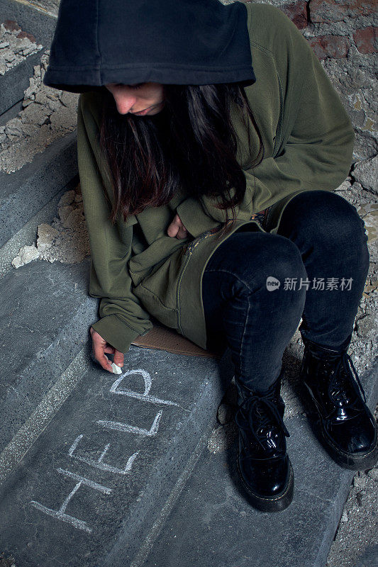 不快乐的女孩在地上写着帮助