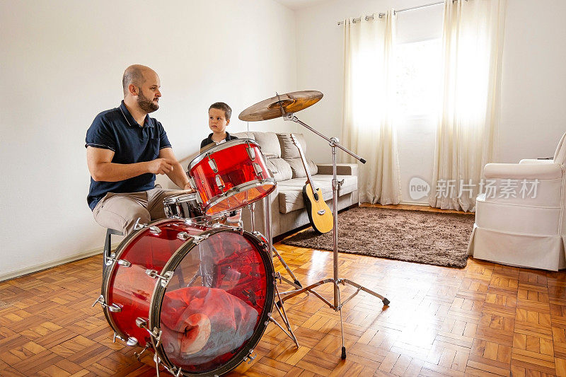 父亲和儿子在家里演奏音乐。