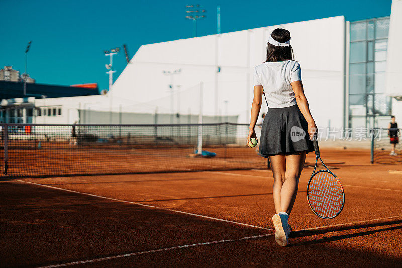 在户外红土场上的年轻女子网球运动员