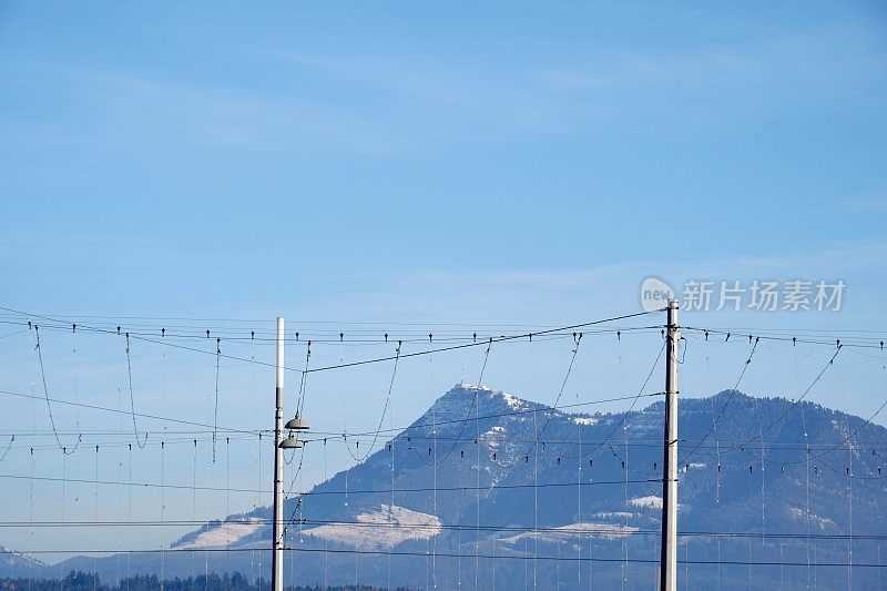 瑞士卢塞恩镇的圣诞户外照明。挂着灯的铁链悬挂在街道和桥梁上。背景是山脉，尤其是瑞吉。