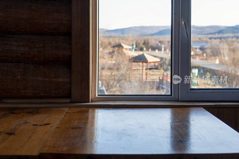 咖啡馆里的一张木桌旁，透过窗户看到了美丽的风景