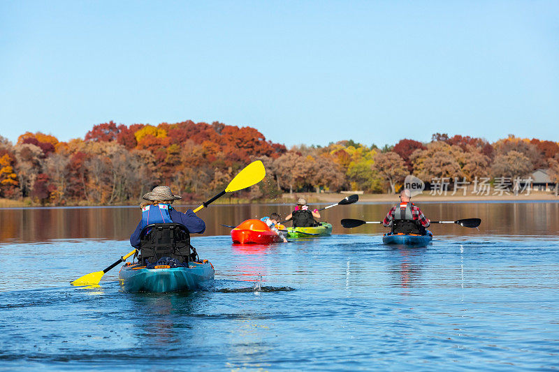 一家人秋天在湖上划皮划艇
