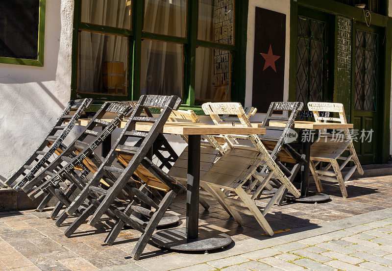 在COVID-19大流行和封锁期间关闭餐厅咖啡馆。隔离和宵禁在公共场所不接待游客。城市街头酒吧里空荡荡的桌椅。