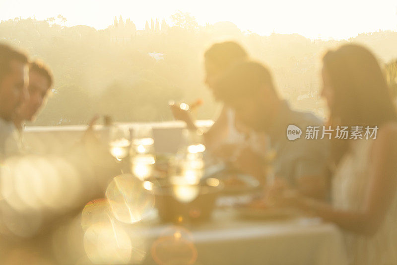 日落时分，朋友们在桌子上一起用餐。