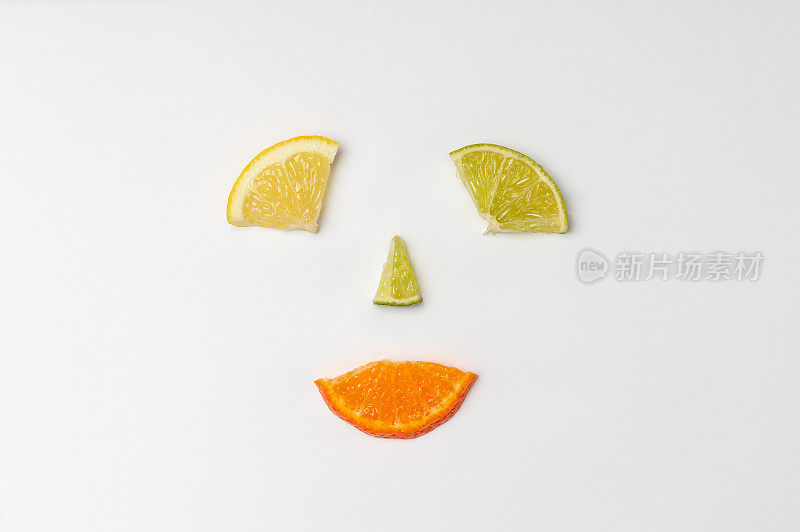 柑橘类水果、橙、酸橙等柠檬片在白色的背景上排列成笑脸。创造力、幸福和观念观念