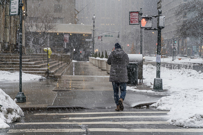 一名年轻游客，在一场大雪中穿过曼哈顿的街道