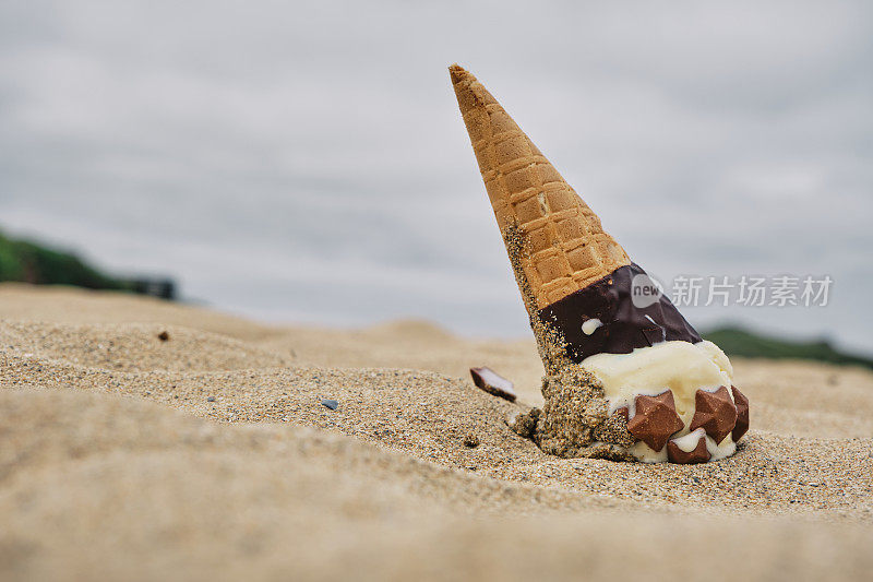 在康沃尔郡纽基的波思海滩，把冰淇淋蛋卷掉在沙滩上。