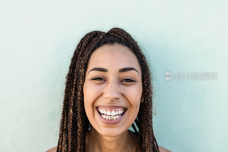 快乐的波西米亚非洲女孩在户外对着相机微笑-关注脸