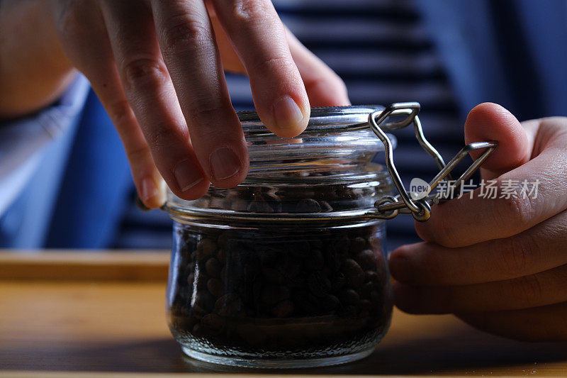 正合上装满烘焙咖啡豆的玻璃罐