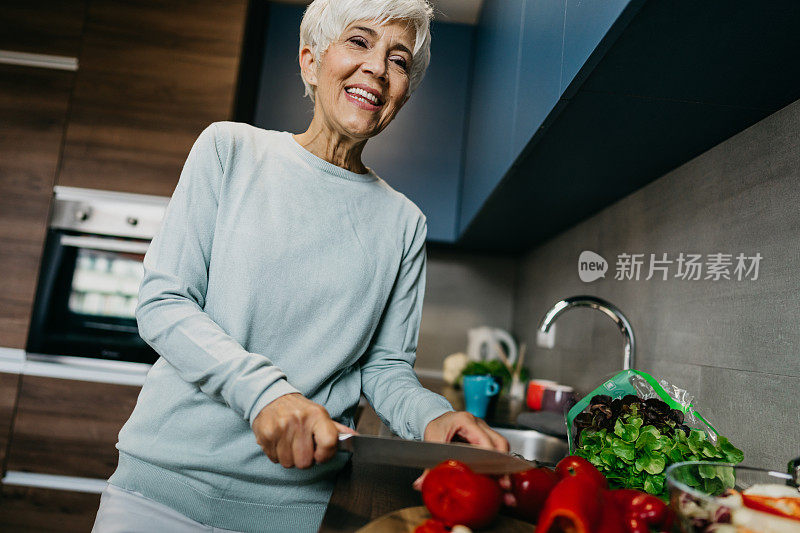 一位女士在厨房里用笔记本电脑打电话