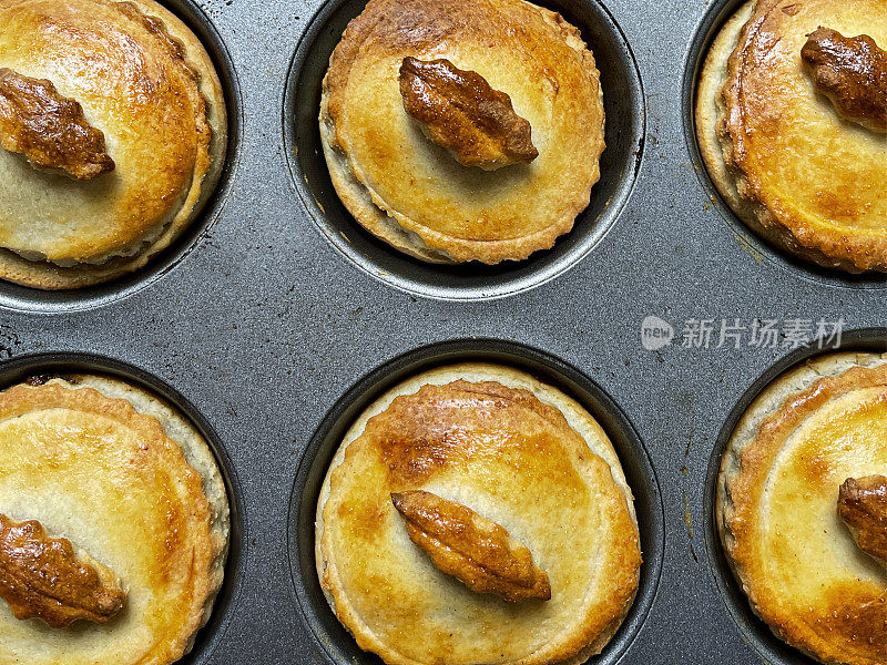 全帧图像的松饼烤盘煮熟，自制的个人肉馅饼，节日圣诞甜点酥皮糕点甜肉馅(混合切碎的干果，蒸馏酒和香料)，家庭烘焙，高架视野