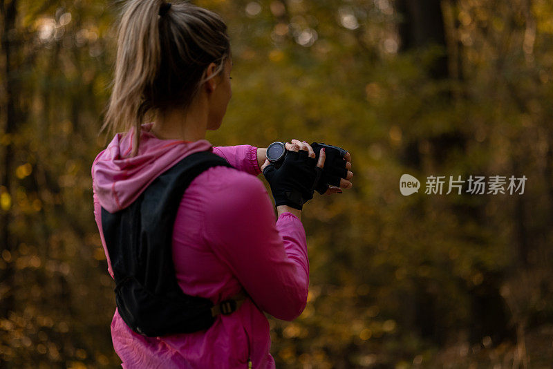 一个白人妇女在自然中做她的日常训练的后视图