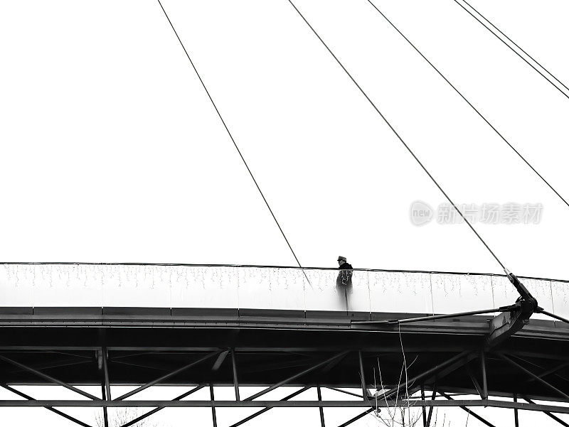 一个人走在公园的桥上。