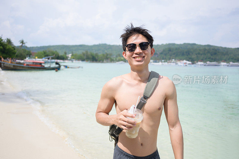 亚洲男人享受夏天阳光明媚的日子凉爽的清晨在普吉岛和甲米的海滩海泰国南部亚洲喝咖啡
