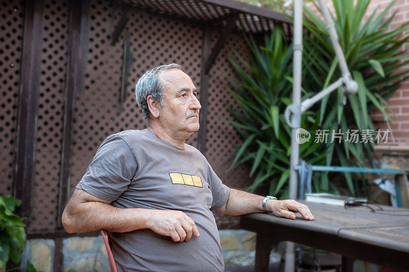 年长的男人坐在阳台上